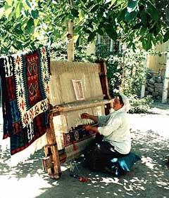 Woman weaving a carpet